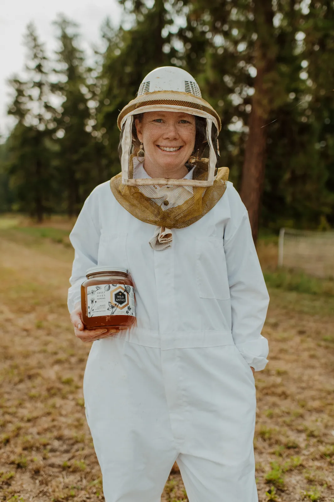 Emily in a veil, holding a jar of Wild Antho honey.